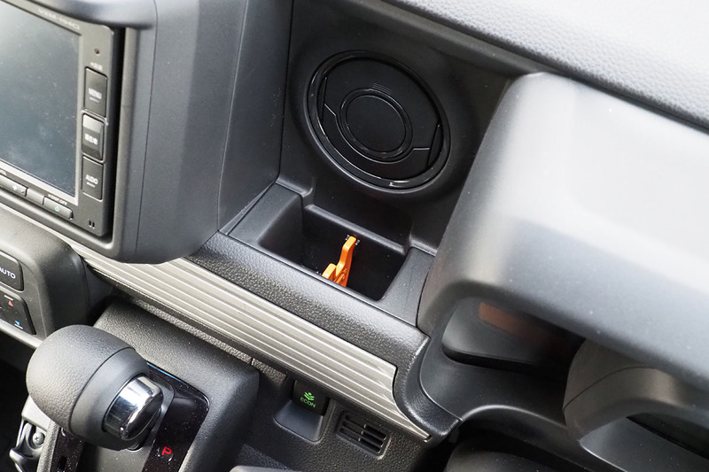 N-VANの「あの部分」。インパネ中央付近にあるアッパーポケットですが、脱着可能なオレンジ色の仕切りがセットされています。USBケーブルなどを巻くことができるスリット入りの仕切りです。使う人は使うけれど、使わない人は使わないし「なんかこの仕切りが邪魔」的に持て余す存在だったりも。