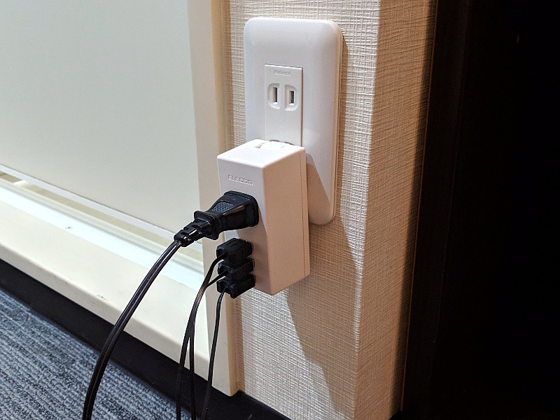 壁面のコンセントに接続したところ。ホテルの余剰コンセントを使っての機器の充電には最適だ