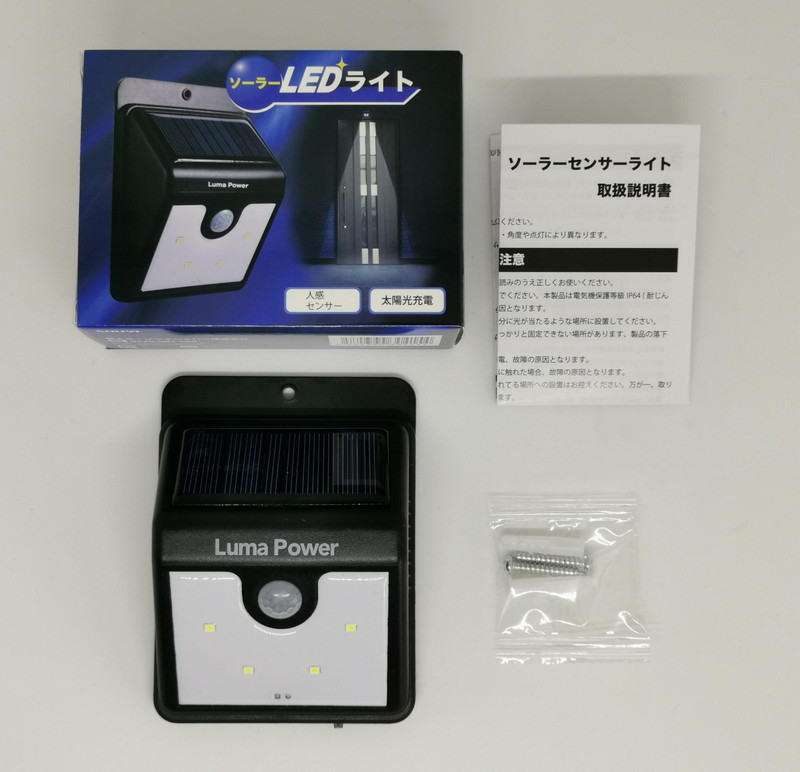 パッケージには、ソーラーLEDライト本体、取り付けネジ2個、留め具2個、そして取説が入っている