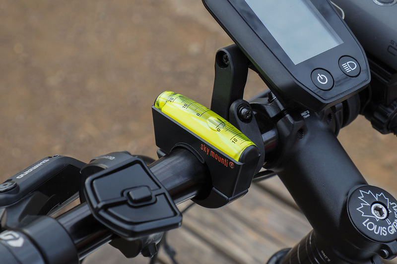 自転車のハンドルにセットした様子。平らな場所で、泡が0％の位置にくる角度で固定します。右写真は約10％の勾配であることを示しています。