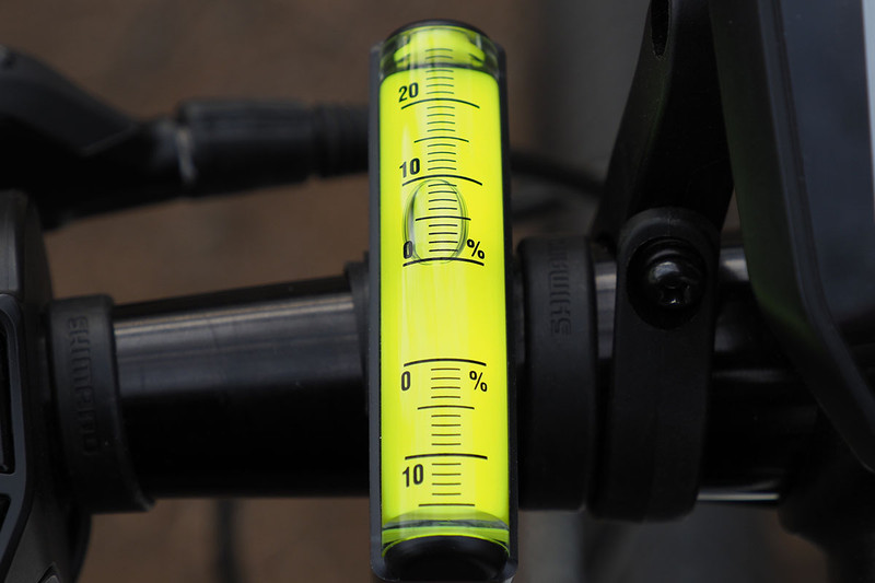 自転車のハンドルにセットした様子。平らな場所で、泡が0％の位置にくる角度で固定します。右写真は約10％の勾配であることを示しています。