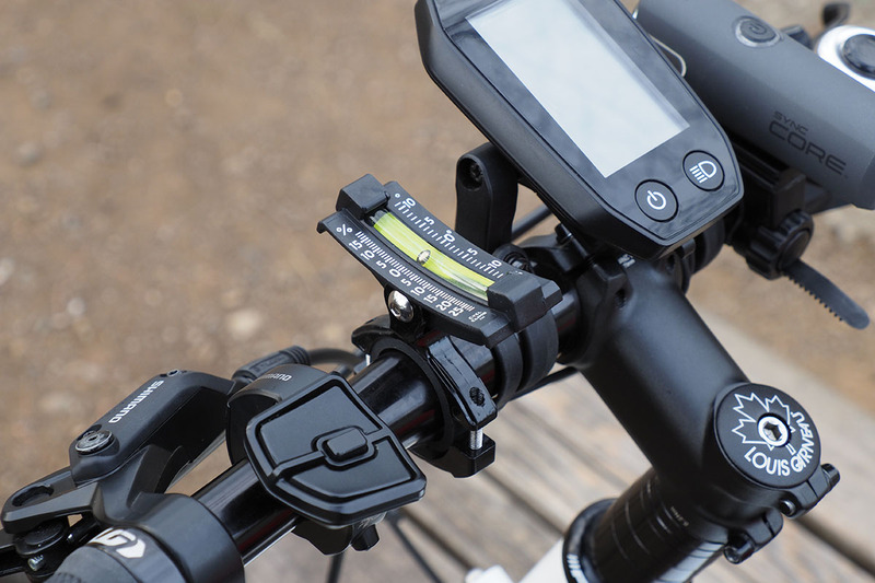 自転車に取り付けた様子。やはり平らなところでインジケーターが0を示すように取り付け、坂の途中でインジケーターの位置を読み取るという使い方です。右は約15％の勾配であることを示している様子。