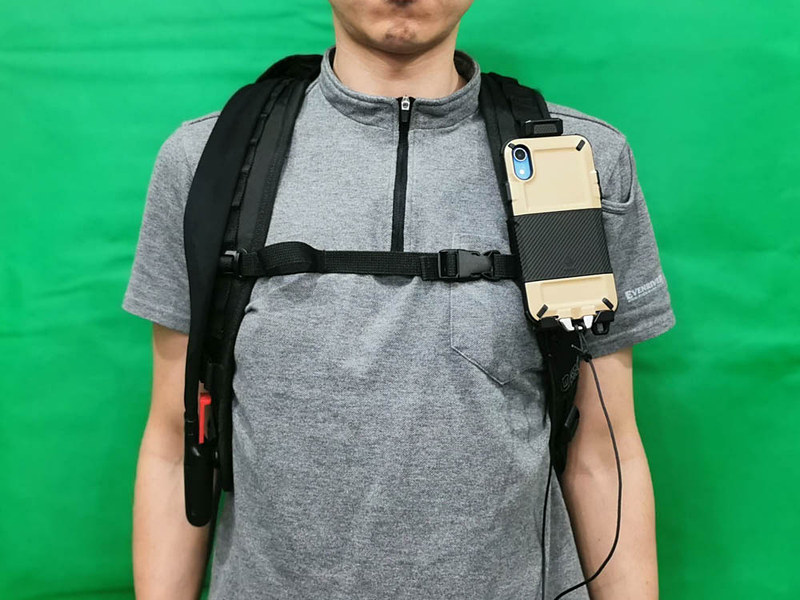 バックパックのショルダーストラップに固定した状態。こんな感じでiPhoneが胸に貼り付いたみたいな感じになる