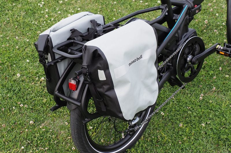 Vektronはミニベロ（小径車）タイプのe-bikeです。激坂でもグイグイ走るので、荷物をたっぷり積んでも大丈夫。というわけでリアキャリア（荷台）を装着し、そこにモンベル「ドライ サイドバッグ 20」をセットしました。1個あたりの容量は10Ｌで、高い防水性能を備えています。ロードバイクなどだとフロント用サイドバッグとなりますが、ミニベロだとリアのサイドバッグとしてちょうどいいサイズ感。お値段は、2個1セットで直販税別価格1万800円。