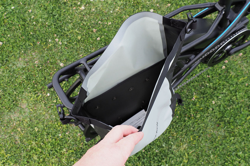 バッグの開口部を開いた状態。上部を合わせてクルクル巻いて閉じるタイプのバッグですね。素材は薄いナイロンで、内部にポリエチレンパネルがあるだけの「袋」って感じ。実際に「ドライ サイドバッグ 20」の重さを測ってみたら、片側で500g行きませんでした。自転車にプラス1kgで計20リットルのサイドバッグが使えるというのはイイ感じ。軽いんですが、堅牢性は十分。バッグ自体は薄いペラペラ系ですが、手でグイグイ引っ張ったくらいでは切れる気がしない。なお、バッグ素材の継ぎ目は熱溶着されているので、ほつれてくるようなこともまずありません。ウレタンコーティングは内側になされているようです。