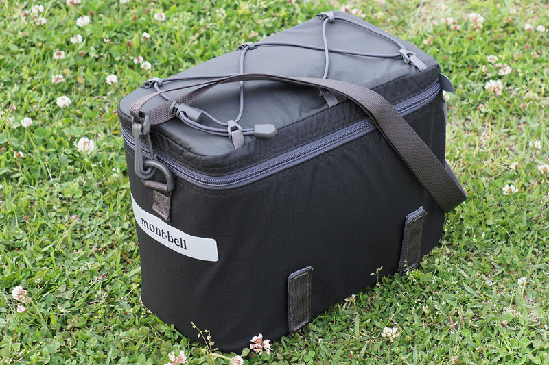 モンベル「ツーリング シートバッグ 9」。サイズは高さ21×幅15×奥行き29cmで、質量は330g、容量は9リットルです。素材は330デニール・ナイロン（リップストップ）。レインカバーとストラップが付属しています。ダブルファスナーで開閉できるややソフトなバッグで、内部には型崩れを防ぐパッドが入っています。フタの内側にはファスナーポケット。開口が大きくファスナーで手早く行えるので、カメラの出し入れが手っ取り早くて便利ですが、内部のパッドはカメラを衝撃から守ってくれるほどのものではありません。なので、カメラ用インナーケースと併用中です。