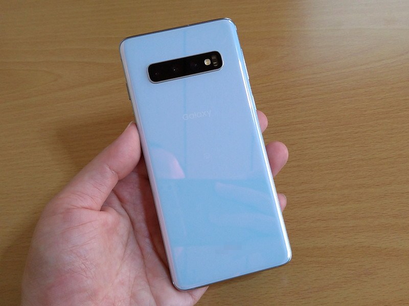 色はプリズムホワイトを選択。ロゴ類は最小限で、背面下側の方にごく小さく、モデル名（SCV41）とIMEIがプリントされているだけ（本写真ではモザイクをかけてしまっているので判別できないかと思います）