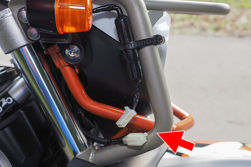 ドライブレコーダーの電源はバイクから取っています。共有のため、ドライブレコーダーの電源ケーブルを脱着可能に改造。コネクターとしてエーモンの「カプラー2極(ロック付・110型)」（<a href="https://www.amon.jp/products2/detail.php?product_code=1198" class="strong bn" target="_blank">公式ページ</a>）を使っています。脱着可能にしたことで、共有ができるようになったのに加え、バイクから離れるときに外せるので盗難からも守れます。ドライブレコーダーから伸びるケーブルの太くなっている部分にはヒューズが入っています。