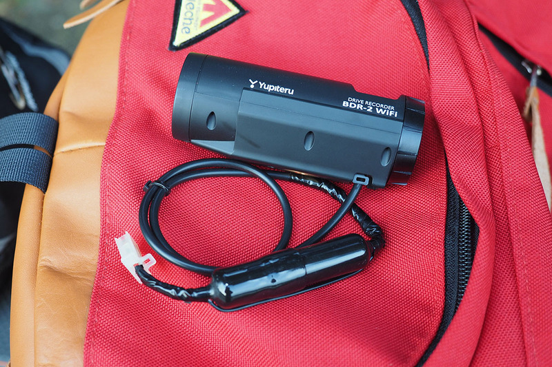 ドライブレコーダーの電源はバイクから取っています。共有のため、ドライブレコーダーの電源ケーブルを脱着可能に改造。コネクターとしてエーモンの「カプラー2極(ロック付・110型)」（<a href="https://www.amon.jp/products2/detail.php?product_code=1198" class="strong bn" target="_blank">公式ページ</a>）を使っています。脱着可能にしたことで、共有ができるようになったのに加え、バイクから離れるときに外せるので盗難からも守れます。ドライブレコーダーから伸びるケーブルの太くなっている部分にはヒューズが入っています。