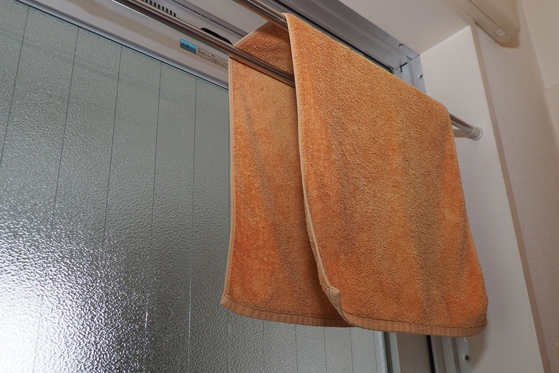 こちらは筆者宅のバスルーム。ドア枠の上部に2本の突っ張り棒を入れ、タオル掛けとして使っています。2本またいでタオルを吊すことにより、タオル面に隙間ができて乾きやすいというわけです。