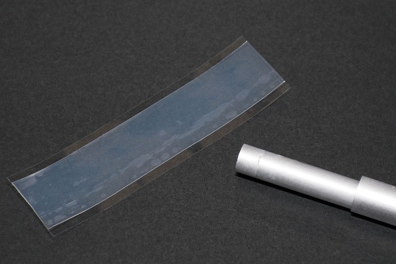 自己融着テープを適当な長さでカットし、キャップが失われた突っ張り棒の端に巻いていきます。自己融着テープは引っ張りながら巻いていくのが基本的な使い方ですが、未使用の状態でテープの間に薄い樹脂シート（セパレーター）が入ったものは、引っ張らずとも圧着すれば融着します。なので、軽く引きつつ対象に巻いていき、ほどよい厚みがでるような感じになればいいと思います。巻いたら指でギュッギュッと押さえて圧着し、テープを融着させて一体化させます。ちなみに、未使用状態でセパレーターが入っていないタイプ（ブチルゴムタイプなど）の自己融着テープは、テープ表面に融着防止の膜があり、引っ張ることでその膜が裂けてテープ素材どうしが触れて融着するしくみです。