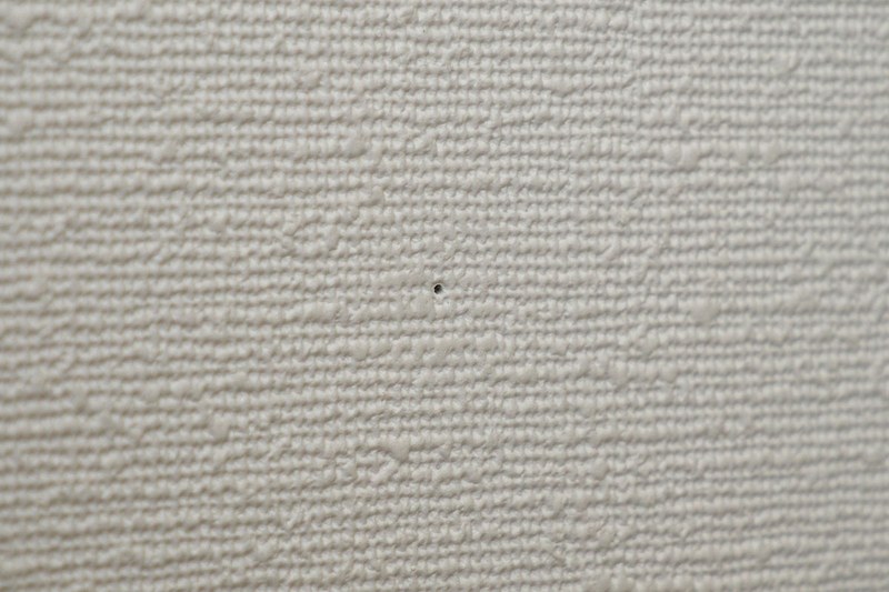 写真のように壁に固定して突っ張り棒を押し当てます。これで突っ張り棒がズリッと滑り落ちることが激減。壁に開く穴もあまり目立ちません。ただしペットボトルキャップや画鋲の固定力・保持力を上回る負荷がかかればズリッとイキますので、過信は禁物です。また、もちろんですが、この方法を使った場合も、突っ張り棒がなるべく強く突っ張るように固定してください。