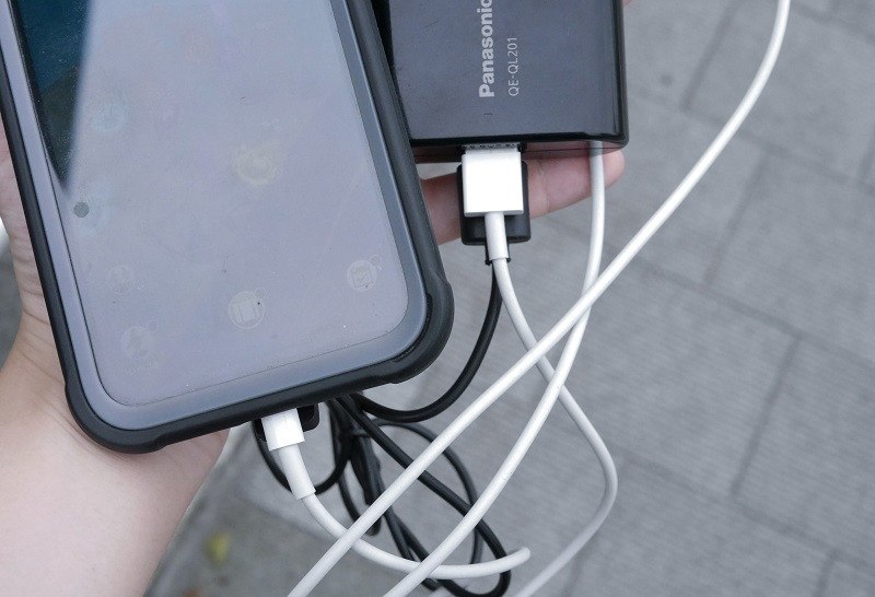 モバイルバッテリーを使って、スマートフォンの充電と製品の給電を同時に行っている様子。モバイルバッテリー自体もかなり熱くなるしケーブルでかさばってしまうのは残念なところ
