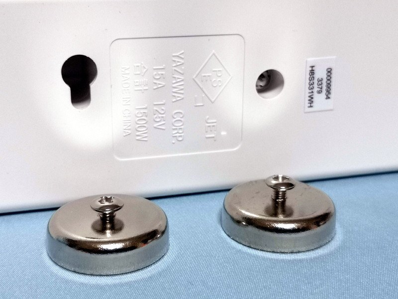 電源タップのフック穴も元々は壁にねじ込んだ丸頭ネジなどにひっかけることを念頭に置いたデザインなわけで、マグネット側にその丸頭ネジを付けてこの穴にひっかけるというのはある種、所定デザイン通りの使い方なのかもしれない