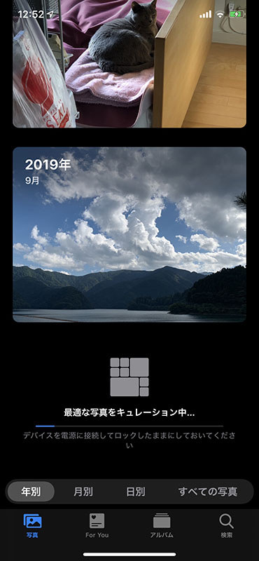 上の写真表示で、日別のみ写真の大小が付いていましたが、これはiOSが自動的に写真を分析・キュレート・レイアウトして表示してくれるためです。上のスクリーンショットはその処理が行わている様子です。結果、似た写真を小さく表示したり特徴的な写真の一部分を大きく表示するようになります。目的の写真を探しやすくなるという印象。