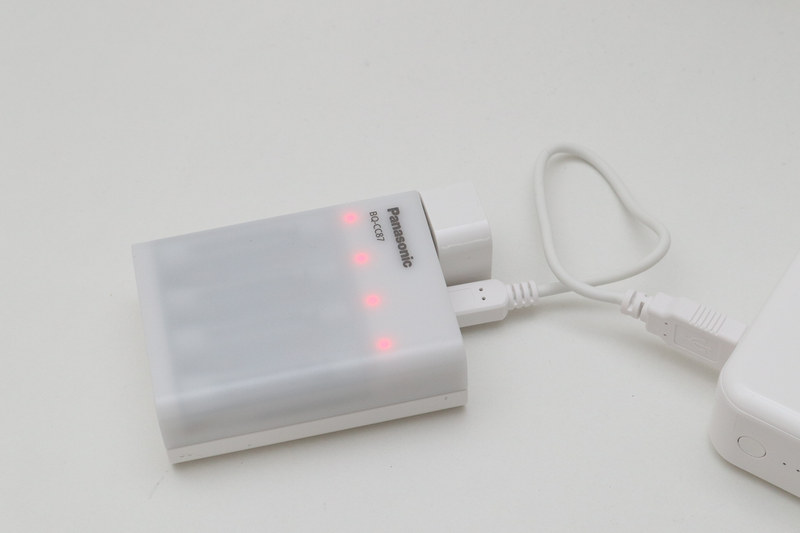 USBバッテリーをつないでニッケル水素充電池を充電中。赤く点灯する