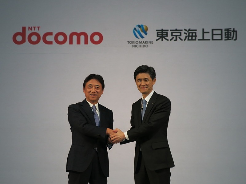 ステージ上でNTTドコモの吉澤社長と握手を交わす東京海上日動火災保険株式会社 取締役社長の広瀬伸一氏（右）