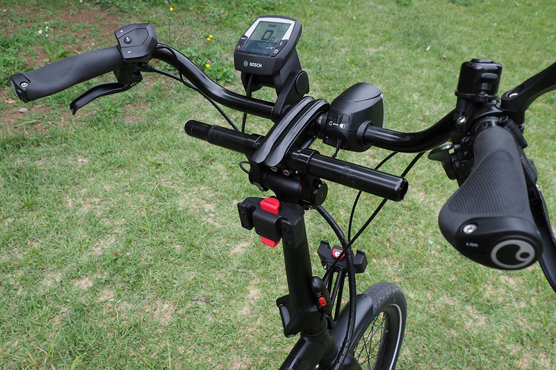 ハンドル部分に独自のハンドル向き・高さ調節機構「アンドロスステム」を持つVektronの場合、一般的なハンドルを装着するには一工夫必要です。写真の工夫は思うところあってちょっとゴテゴテ気味。通常はハンドル径調整用のシム（パイプ径を太くする調整用部品）を使うことになると思います。小径車にプロムナードハンドルはなかなか似合う。乗車姿勢もラクになり、手首の痛みもなくなりました。