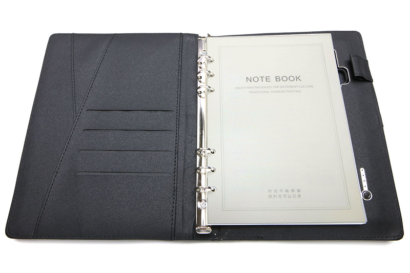 ソウイジャパンの「充電ノート SY-106」。A5サイズ6穴タイプのリフィルをセットできるリフィルノートカバーで、8000mAhのモバイルバッテリーを内蔵しています。内蔵のUSBケーブルおよび表紙部分のQi充電パッドでスマートフォンなどを充電可能。ありそうでない、なかなかユニークな製品です。