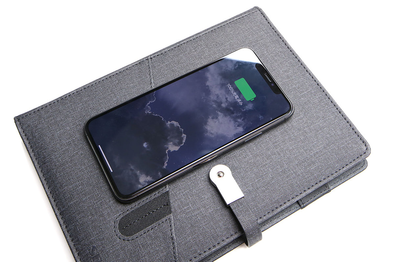 表紙部分の中央がQi充電パッドになっています。ここにQi充電対応端末などを置いて充電。また、大きい方のポケットに端末を入れてQi充電することもできますので、歩きながらなどの移動中でもQi充電を行えます。