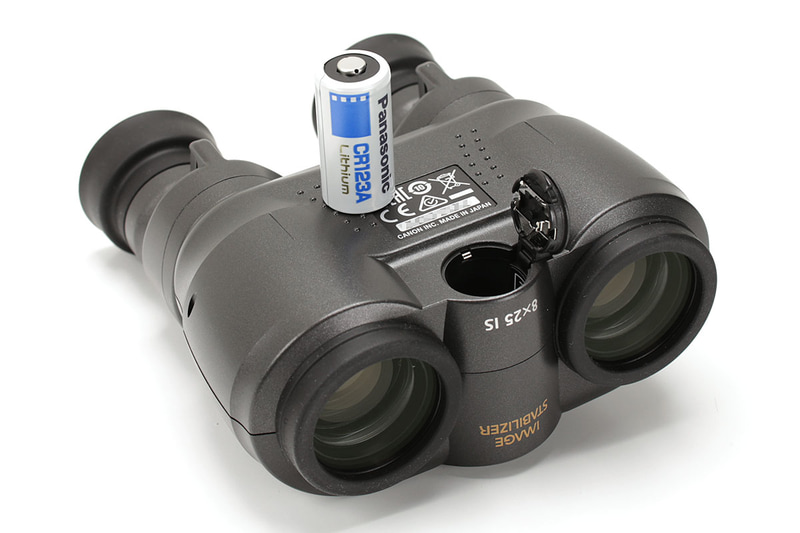 倍率8倍のキヤノン「8×25 IS」。上のボタンを押している間だけ光学式手ブレ補正機構が働きます。電池はCR123Aリチウム電池×1本で、電池別の質量は約490g。手ブレ補正の連続動作時間は常温（25℃）で約6時間。わりとコンパクトで気軽に持いて使えます。メーカー希望小売価格は税別5万5000円で、実勢価格は2万8000円前後。