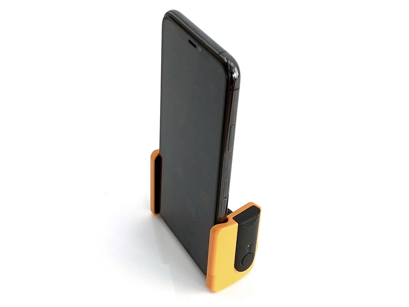 縦向きにも自立します。スマートフォンにグリップ本体をセットしたまま携帯できるポーチと、それを首などから吊せるストラップ、ミニ三脚などが付属します。