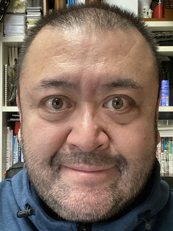 小さいほうのリングライトをスマホに装着して自撮りした様子。左がライトがオフで、右がライトがオン。むさ苦しい顔で恐縮ですが、リングライトを使って撮ると顔全体が明快に写り、さらに目にリング状のキャッチライトが入り、シワが軽減されたりもして、より好印象な自撮り写真が得られます。