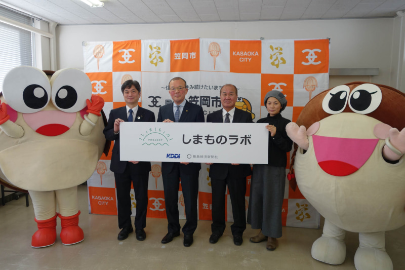 しまのもプロジェクト開始の記者発表会。左からKDDI 中国総支社 管理部長の小野隆氏、岡山県笠岡市の小林嘉文市長、NPO法人かさおか島づくり海社 理事長の鳴本浩二氏、離島経済新聞社 統括編集長の鯨本あつこ氏。両サイドを固めるのは笠岡市のゆるキャラ、カブニくんとカブ海さん