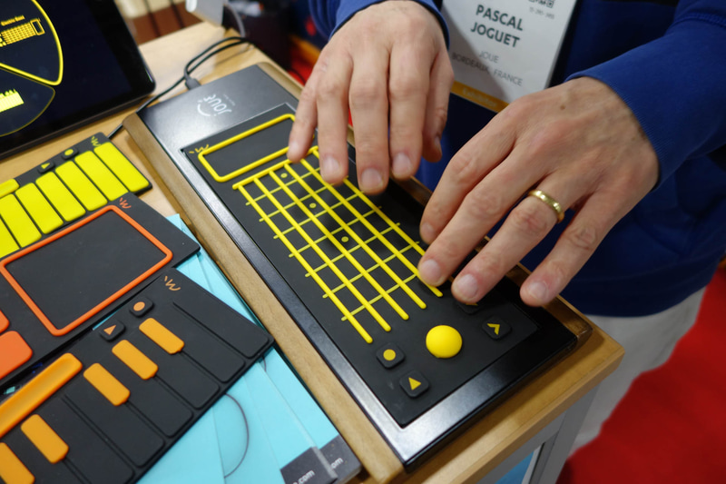 PLAY。ただの板にしか見えないが、ギターを弾くように左手で押さえつつはじくと音が鳴る