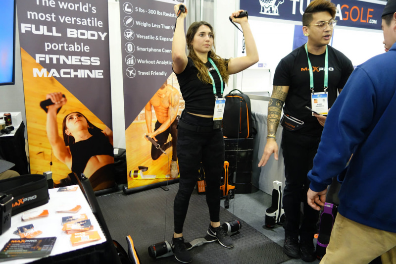 お姉さんが踏んづけているのがMAXPRO CONNECTED。コードを引っ張る強度は本体左右のダイヤルで調整できる