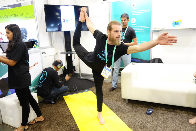 YogiFiの上でなかなかの難易度なヨガポーズを決めているが、実はこのとき、無線接続に異常があって実機デモが行なえていない（この手の展示会のあるあるネタ）