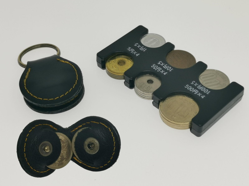 現在も筆者が愛用している革製の500円硬貨が2枚収納できるキーリング（左）と今回手に入れた約3倍ほどの現金硬貨を持ち歩ける携帯コインホルダー（右）