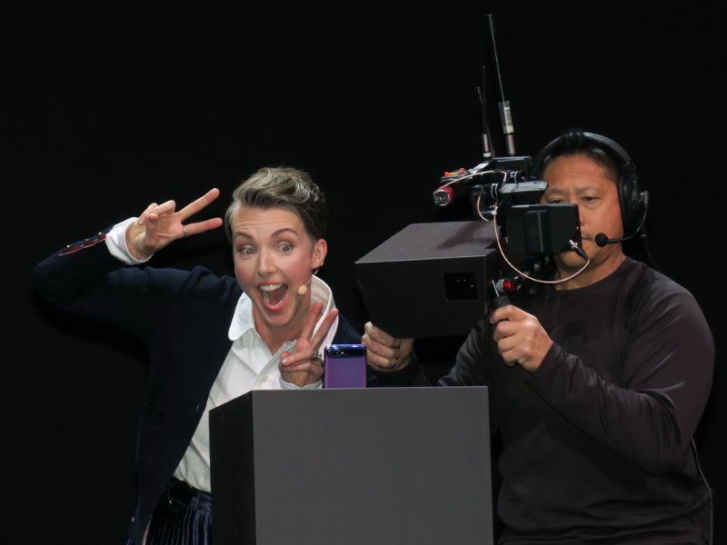 ステージ上でノリノリの笑顔でセルフィーをデモ