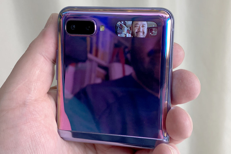 左写真は着信中の表示。カバーディスプレイはタッチ操作ができ、着信中にスワイプ操作などをすれば、端末を開かずにスピーカーホン通話ができたりもする。右写真は端末を閉じた状態でアウトカメラによる自撮りをしている様子。電源ボタン2度押しでこの機能が使える。表示は鮮やかで見やすいが、ファインダーとしては写真の一部しか表示されないので、重要な被写体を中央に入れて撮影するといいだろう。