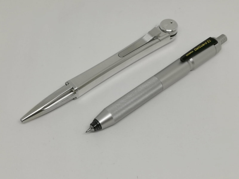 普段から愛用しているアルミ削り出しボールペンのMechaSEA（左）と並んでも引けを取らないデルガード0.5＋SMART-JACKET（右）