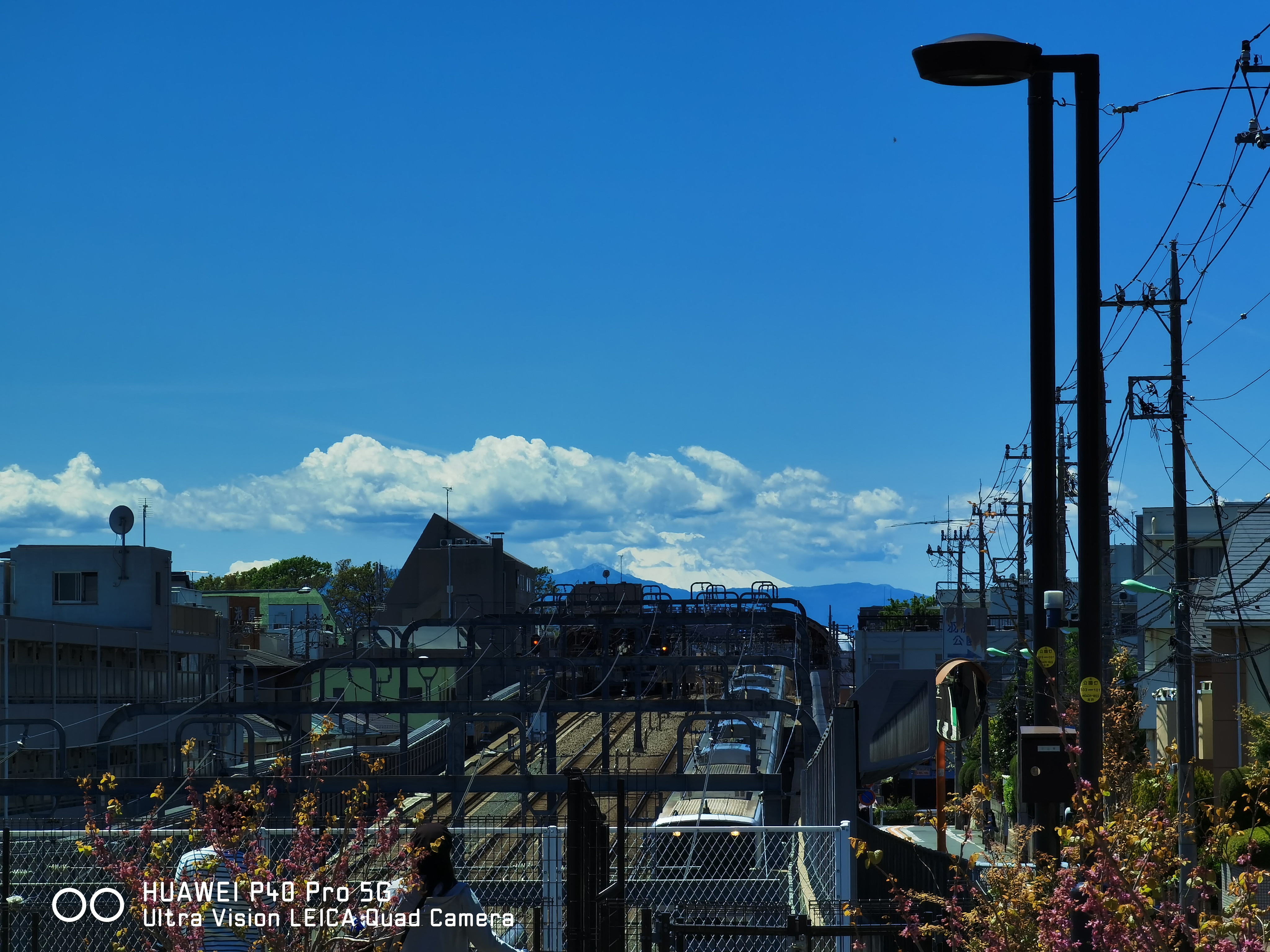 5倍ズームの画面。遠くに雲がかかった富士山が見える。青空はやや強調気味