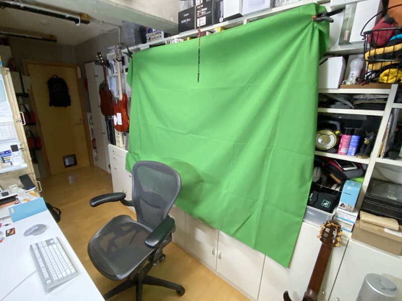 そこでグリーンスクリーンを用意。1.5m×2.0mで強力クリップ×3個付きの品を、Amazonにて2898円で購入した。それを自分の背後に吊す。