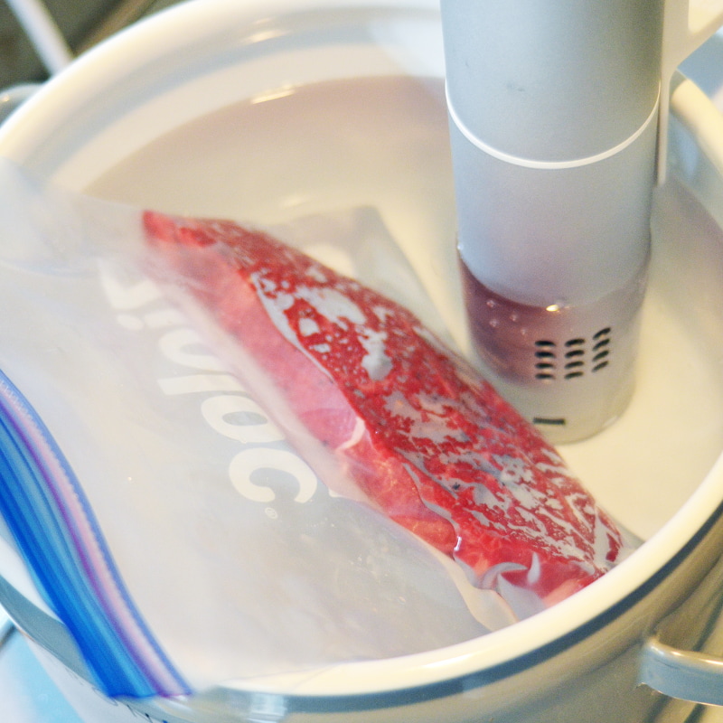 フリーザーバッグに入れてお湯の中に漬け、60℃で1時間煮ます