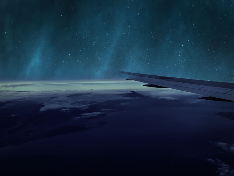 こちらは、飛行機からの風景（左）に天体レンズを適用させた（右）写真。天体の合成に加えて写真も調整される