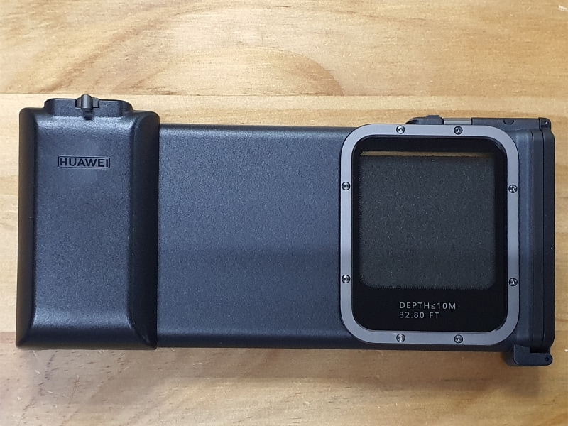 背面はカメラ部分用に大きな窓が開いている。左側のグリップにシャッターボタンなどを備える