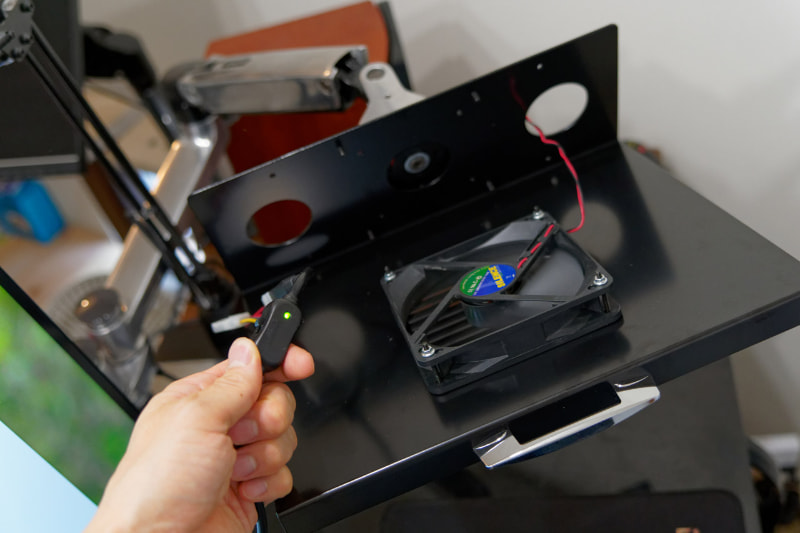 <a href="https://k-tai.watch.impress.co.jp/docs/column/todays_goods/1202960.html" class="strong bn" target="_blank">DC 12Vで電力供給できるスイッチ付きのACアダプター</a>をファンに接続。LED搭載の光るファンを使うとゲーミングな雰囲気も演出できそう