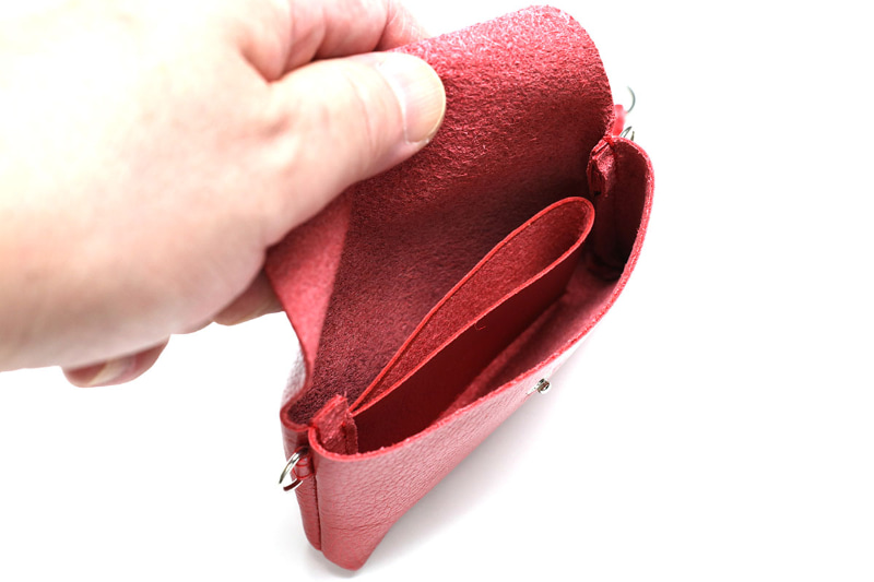 フラップはスナップボタンで開閉でき、内部はざっくりと3つの部屋に分かれている。中央の仕切りは開口が1箇所の袋状で、硬貨や折った紙幣を入れられるが、カードはギリギリ入らない。