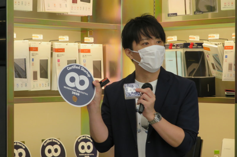 KDDI 石井氏。認定マークバッジに加えて「暑いからうちわも作った」