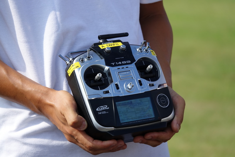 左＝手動操縦用のプロポ。右＝自動操縦の制御用アプリ