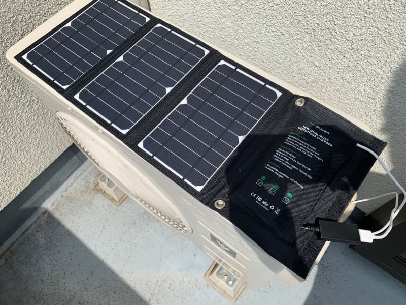 ▲南側のベランダにあるエアコンの室外機に置いて置いてみたところ。かなり日光が当たっているはずなのだが、なぜかうまく充電できなかった