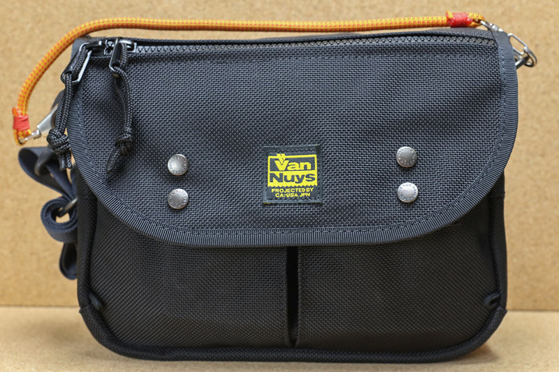 主に使っているモバイルバッグことバンナイズ<a href="https://www.vannuys.co.jp/official/new_item/ve204/" class="strong b">「メールバッグショルダー/Ver.2/240」</a>。幅24×高さ18×奥行き9cmのショルダーバッグで、大きめのポーチというイメージ。ポケットが多いので携帯品を整理整頓しつつ持ち歩ける。ショルダーバッグで手で持つことは想定していないバッグだが、ハンドストラップを追加して手で持てるようにしている。