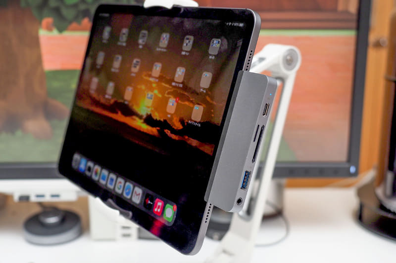 スタンドにセットした11インチiPad Proに「HyperDrive iPad Pro 6-in-1 USB-C Hub」を装着した様子。なかなかスッキリ。邪魔と感じるときはiPad画面を180度回転させればOK……なのはiPad的には当然だが、ノートパソコンなどと違ってカードスロットやポートの位置を左右上下自由にもっていけるって、実はすご〜く便利なことだったりしますな♪