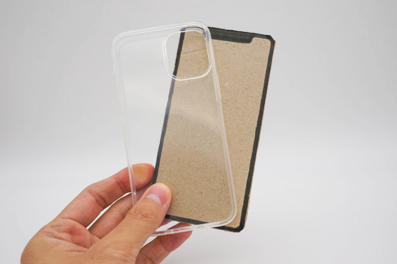 iPhone 12 mini（ボール紙）とサードパーティ製のクリケース。やはり小さい。早く実機に触りたい……