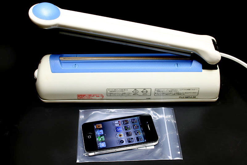 2013年頃、iPhone 5sをビニール袋に封入して防水するの図。ビニール袋に端末を入れ、その後シーラーを使って端末サイズピッタリにし、余った部分を切り落とした。自転車で長距離走る時はこのスタイルであった