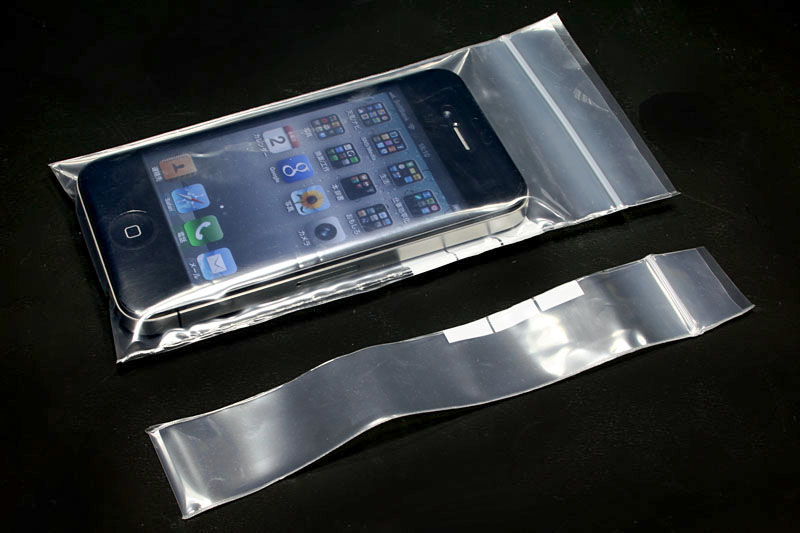 2013年頃、iPhone 5sをビニール袋に封入して防水するの図。ビニール袋に端末を入れ、その後シーラーを使って端末サイズピッタリにし、余った部分を切り落とした。自転車で長距離走る時はこのスタイルであった